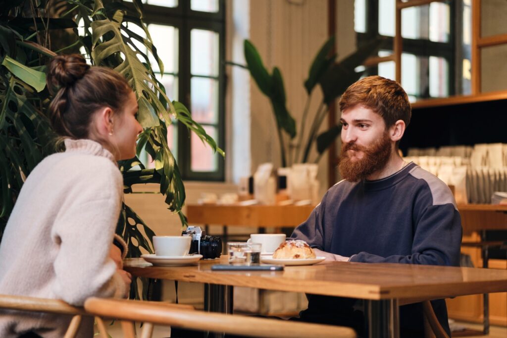 Young attractive couple drinking coffee resting together in cafe